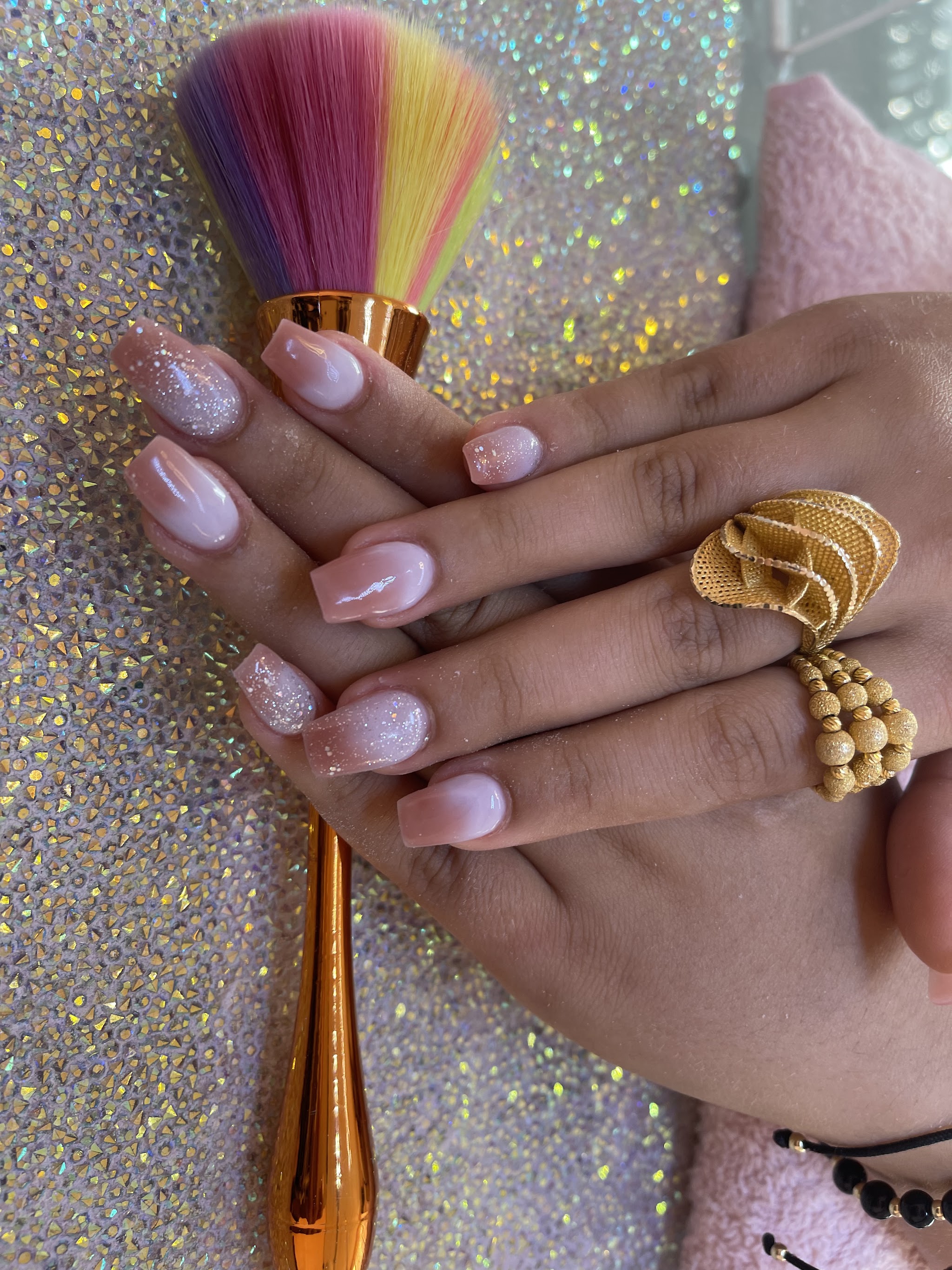 Ombré nagels met glitter, naast een regenboogkwast