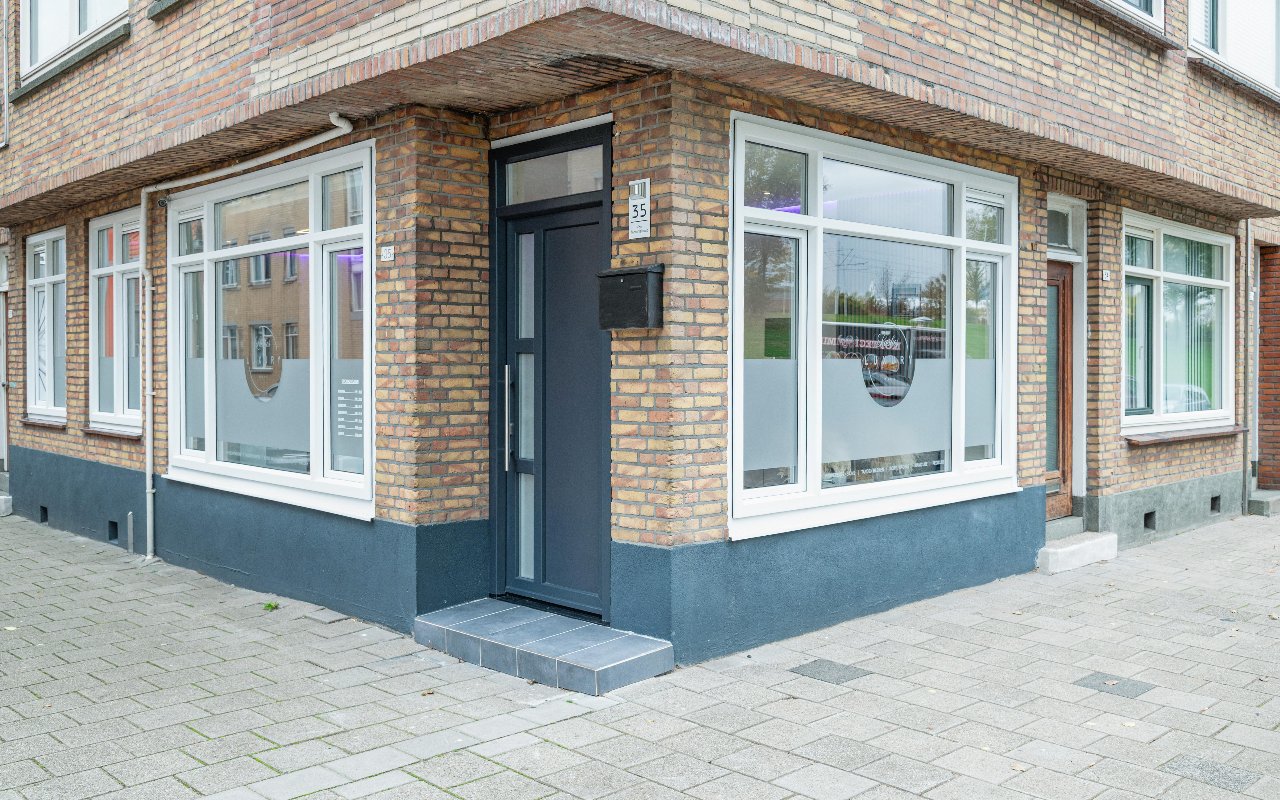De hoekingang van Lashes Luxury met grijze deur en witte kozijnen