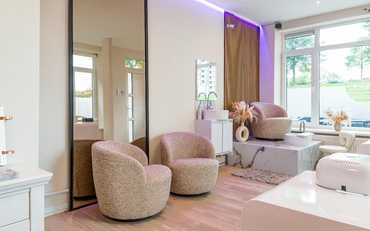 Twee bouclé fauteuils en de pedicurebak bij de spiegel